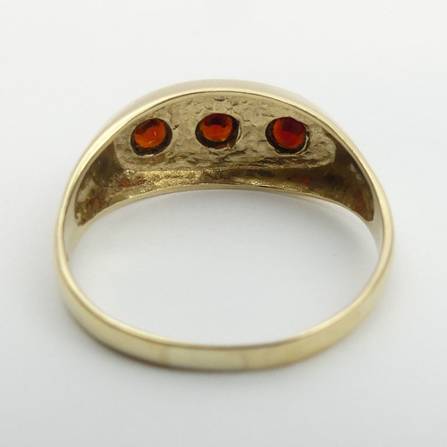 3 - 9ct gold three stone garnet ring, 3.4 grams. Size v, 9 mm. UK Postage £12.