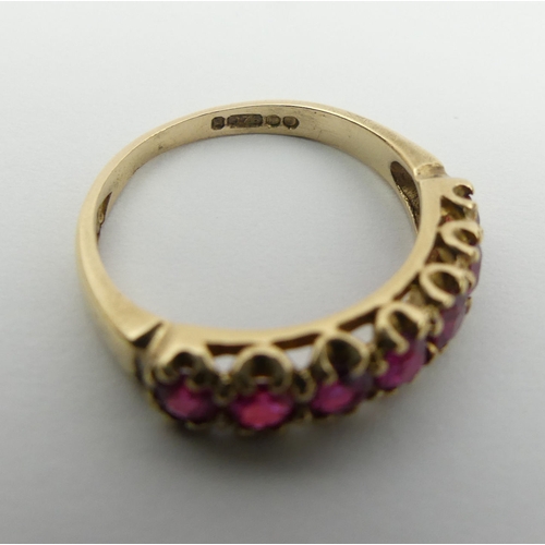 27 - 9ct gold seven stone ruby ring, 2 grams, size L 4.5mm wide.  UK Postage £12.