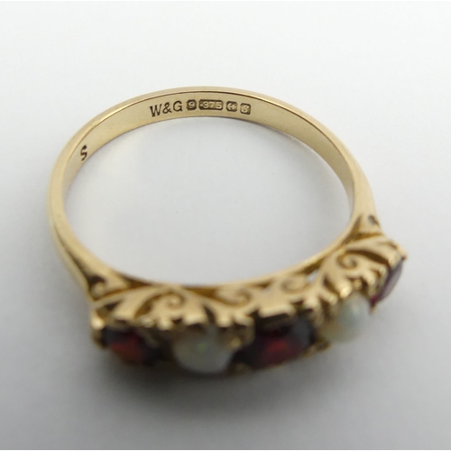 53 - 9ct gold garnet and opal five sone ring, 2.5 grams, Birm. 1967, Size P, 5mm wide. UK Postage £12