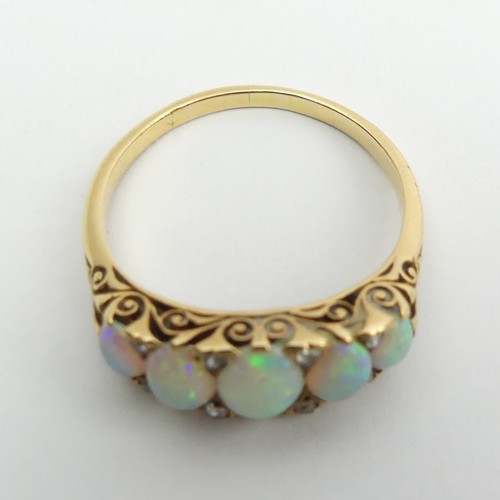 49 - 18ct gold, tested, opal five stone ring with diamond points. 3.9 grams, Size Q1/2, 7.4mm wide. 
UK P... 