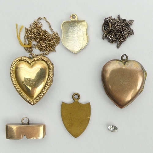 34 - A small box containing two gold back and front lockets, two chains, two shields and a gold mount. UK... 