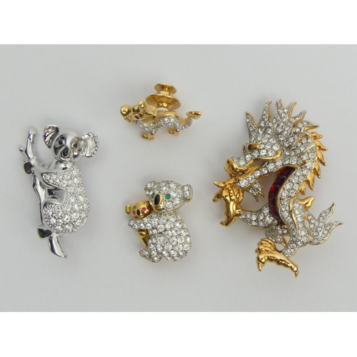 35 - Three Swarovski crystal brooches and a dragon pin, largest dragon brooch 50mm. UK Postage £12.