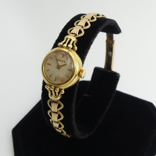 97 - 18t gold Ladies Rolex manual wind, dating from 1954, on a rolled gold strap, 20mm including button. ... 