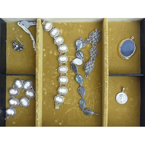 31 - A jewellery box and contents including silver bracelets, lockets, lava cameo brooch, rings and penda... 