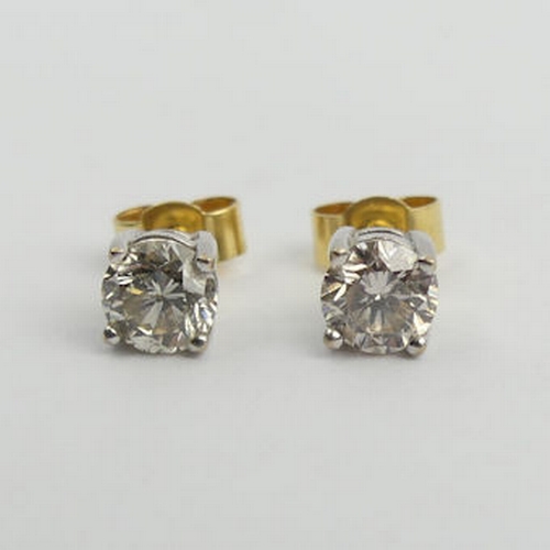 69 - A pair of 18ct gold diamond stud earrings approx 1ct, 1.5 grams, 5mm dia. UK Postage £12.