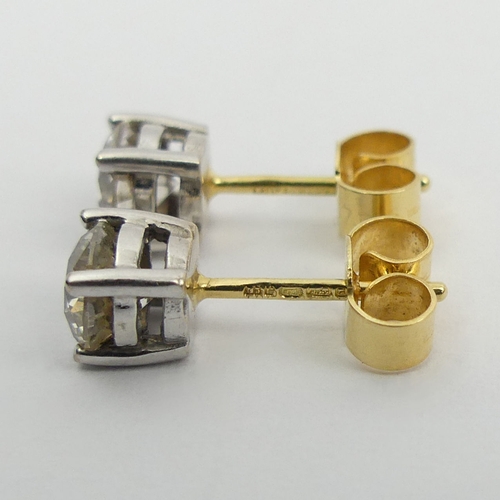 69 - A pair of 18ct gold diamond stud earrings approx 1ct, 1.5 grams, 5mm dia. UK Postage £12.