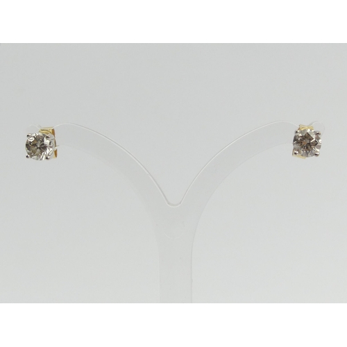 69 - A pair of 18ct gold diamond stud earrings approx 1ct, 1.5 grams, 5mm dia. UK Postage £12.