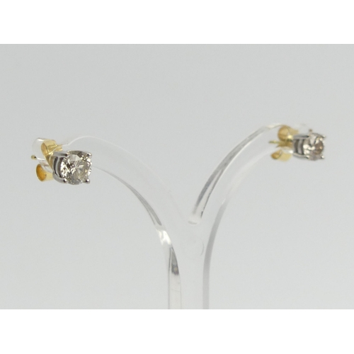 69 - A pair of 18ct gold diamond stud earrings approx 1ct, 1.5 grams, 5mm dia. UK Postage £12.