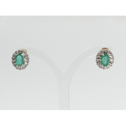 82 - A pair of 18ct gold emerald and diamond earrings, 3.7 grams, 12mm x 10mm.  UK Postage £12.