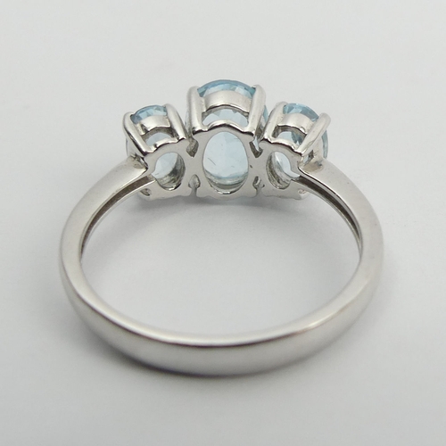 94 - 9ct white gold blue topaz trilogy ring, 2.7 grams, 8.1mm, size M. UK Postage £12.