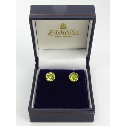 104 - A pair of 9ct gold peridot earrings, 2 grams, 7mm.  UK Postage £12.