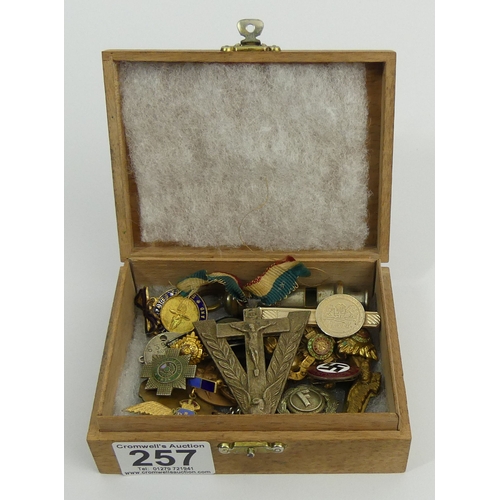 257 - A box of military cap badges and other items of interest. UK Postage £12.