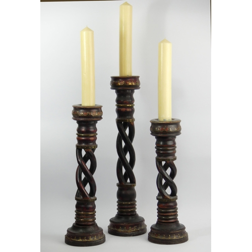 375D - A group of three graduated open barley twist candlesticks. Tallest 62.5cm (excluding the candle). Co... 