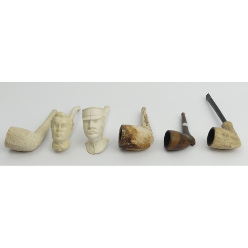 Six clay pipes including a French general with a monocle, a man, claw ...