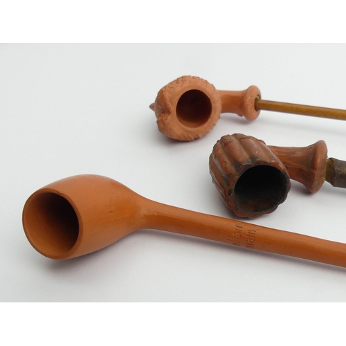 406 - Three terracotta pipes, a fluted bowl marked Hippolyte Leon Bonnaud Marseilles, unsmoked plain pipe ... 