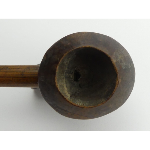 449 - A Korean carved wood pipe with bamboo stem, 76cm, and another similar bowl. UK Postage £12.