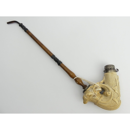 451 - A large meerschaum elbow pipe carved with a dog finial at the rear and a shield with a medieval face... 