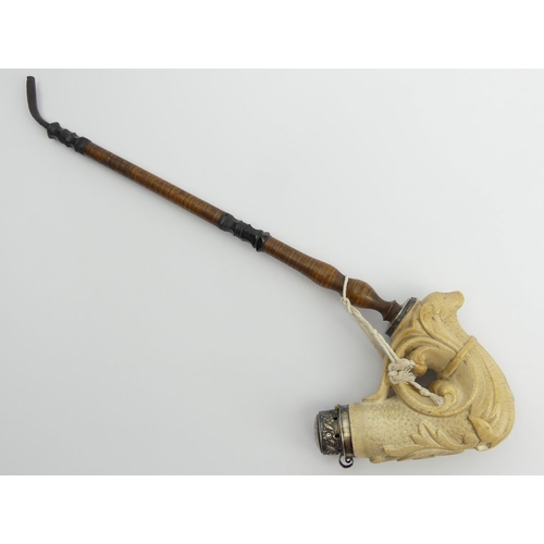 451 - A large meerschaum elbow pipe carved with a dog finial at the rear and a shield with a medieval face... 