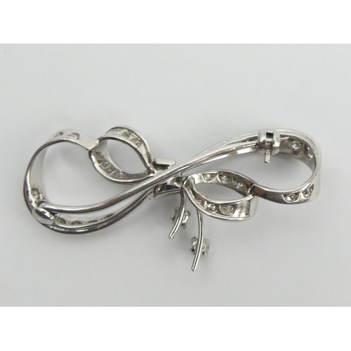 72 - Platinum (tested) diamond set bow brooch, 5.9 grams, 42mm.