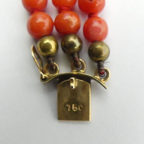 92 - Coral three strand bead bracelet with an 18ct gold clasp, 14.1 grams, 17.5cm x 1.1cm.