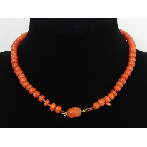 118 - Coral bead necklace with a carved acorn design clasp, 14.9 grams, 29cm.