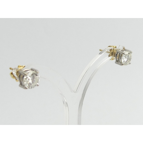 125D - A pair of 18ct diamond stud earrings, each approx. 1 carat, 2.8 grams, 6.4mm diameter.