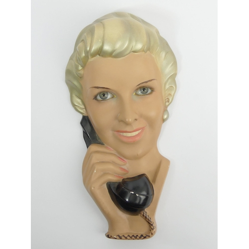 382 - Art Deco plaster wall mask of a lady on the telephone, glass eyes and simulated eye lashes, 39cm.