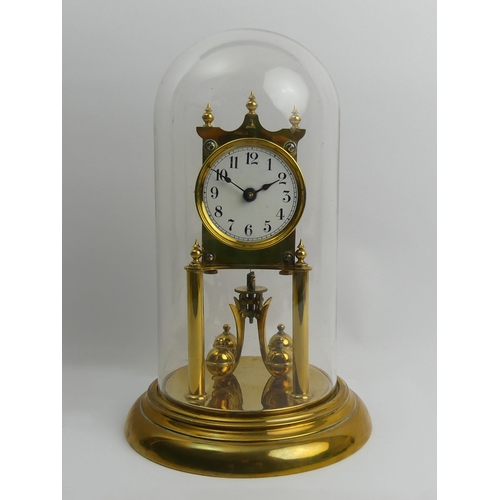 408 - Brass anniversary clock with an enamel dial and glass dome, 30cm.