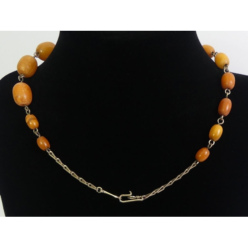 119 - Butterscotch amber bead and yellow metal necklace, 11.8 grams, 35cm.