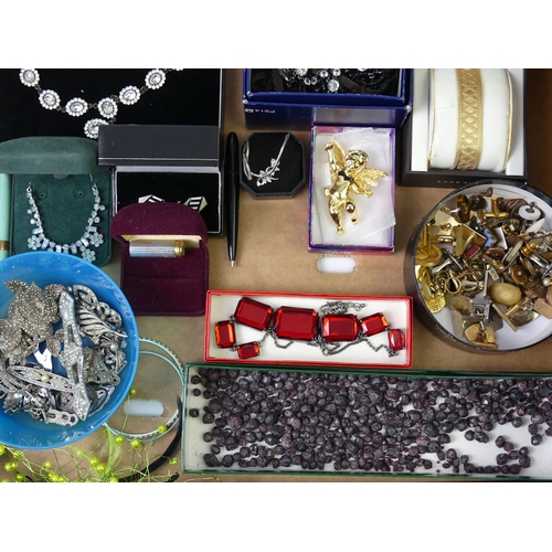 43 - A box of costume jewellery including marcasite brooches and loose garnets.