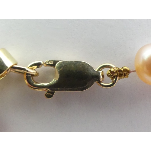 82 - A cultured pearl bracelet suspending a 9ct gold and carnelian cross, 9.5 grams, cross 40mm.