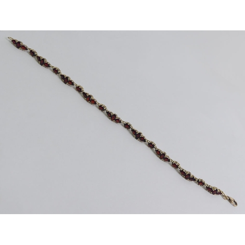 125A - 9ct gold garnet bracelet, 8.5 grams, 20cm x 5mm.