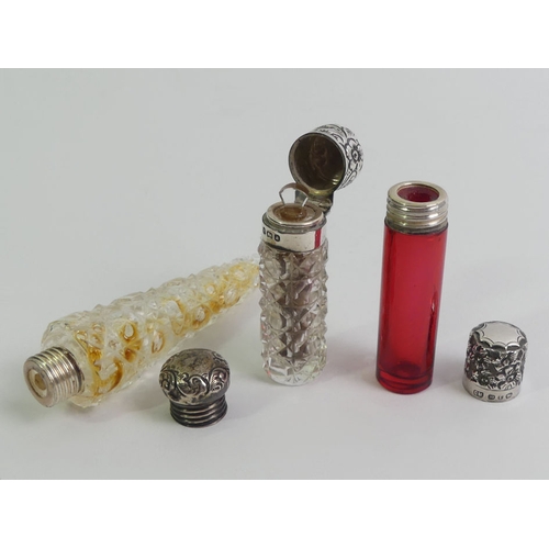 164 - Two Victorian silver topped glass scent bottles along with an Edwardian example, longest 11cm.