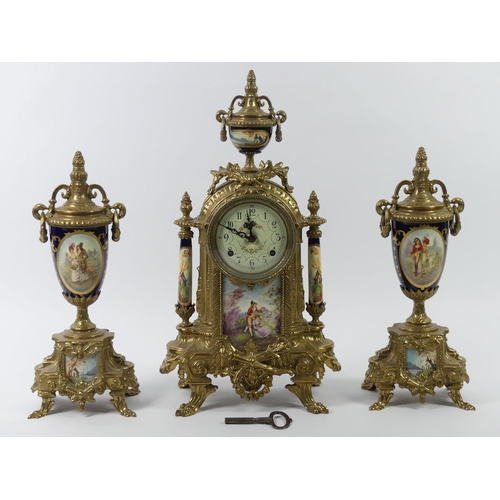 315 - An ornate brass clock garniture with porcelain panels, the clock striking on a bell, 43cm.