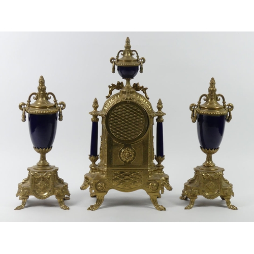 315 - An ornate brass clock garniture with porcelain panels, the clock striking on a bell, 43cm.