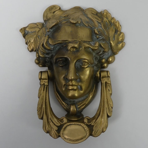 317 - Ornate brass door knocker in the form of a classical head, 19cm x 15cm.