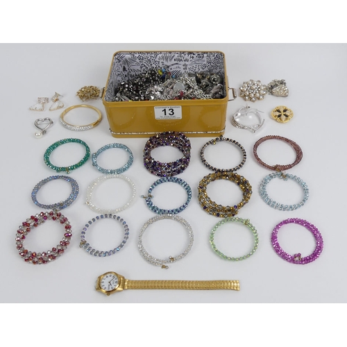 13 - A tin of good costume jewellery including crystal bangles.