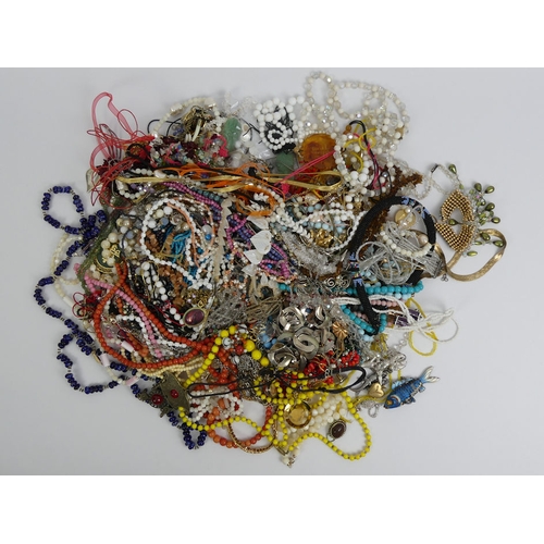 25 - A box of mixed costume jewellery, including an articulated enamel fish pendant.