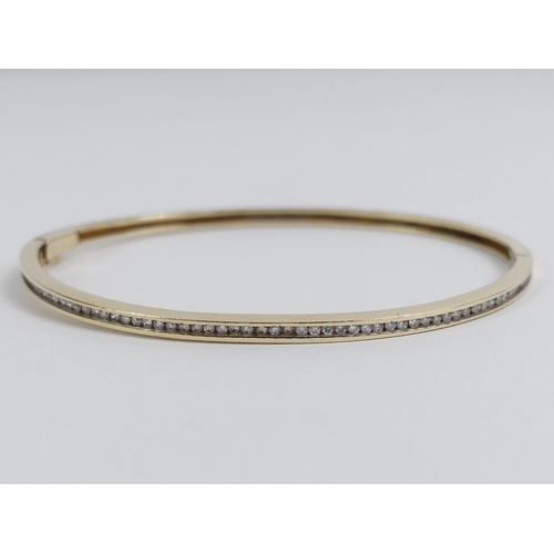 65 - 9ct gold diamond set hinged bangle, 8.1 grams, 2.6mm.