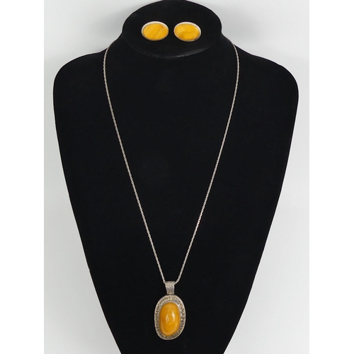 93 - Silver and butterscotch amber pendant and chain with a similar pair of earrings, pendant 55mm.