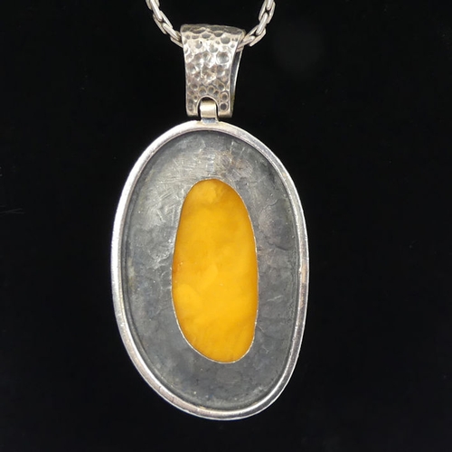 93 - Silver and butterscotch amber pendant and chain with a similar pair of earrings, pendant 55mm.