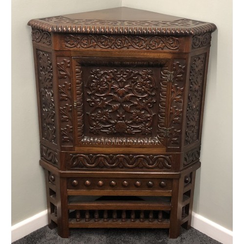 507 - A ornately carved Edwardian walnut corner cupboard. 105 x 74cm.