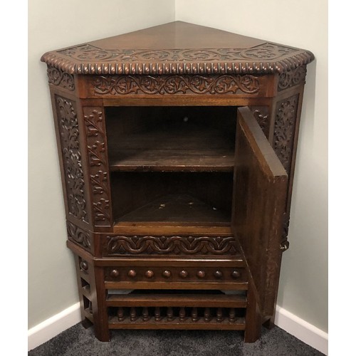 507 - A ornately carved Edwardian walnut corner cupboard. 105 x 74cm.