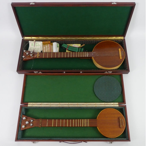 309 - Two mahogany five string banjos in fitted wooden cases, 65cm and 77 cm.