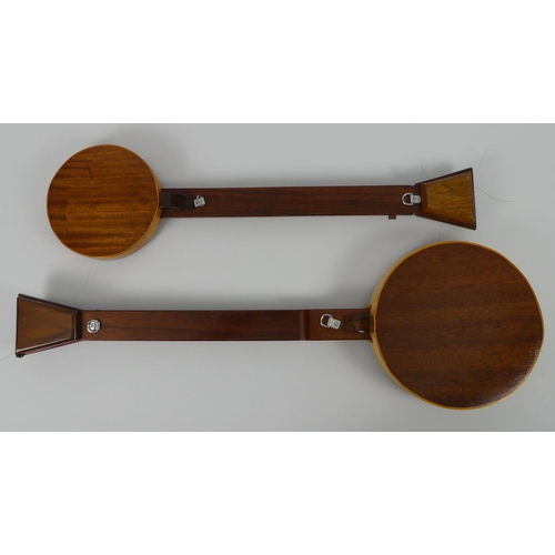 309 - Two mahogany five string banjos in fitted wooden cases, 65cm and 77 cm.