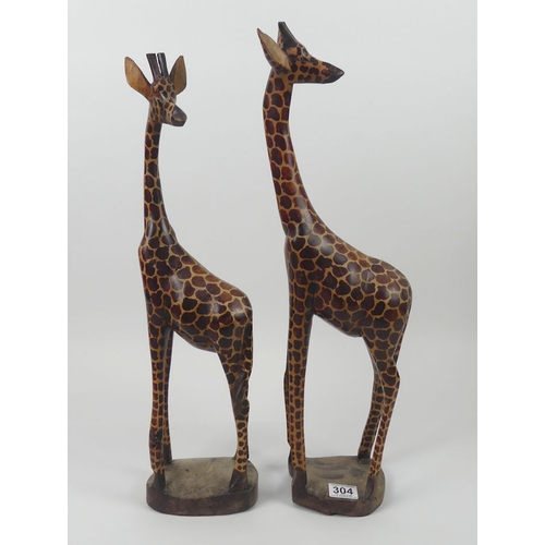 304 - A large pair of carved wooden giraffes. H60cm x W16cm.