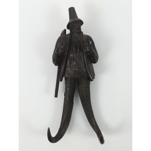 306 - Black Forest finely carved wood and chamois horn coat hook in the form of a hunter. 23 cm high.