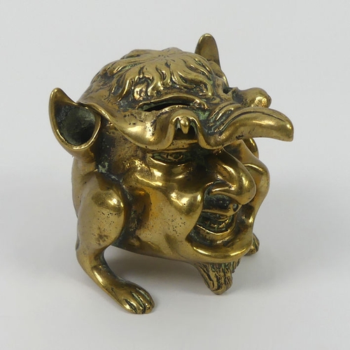 307 - A Victorian grotesque brass inkwell and penholder. 8 cm high.