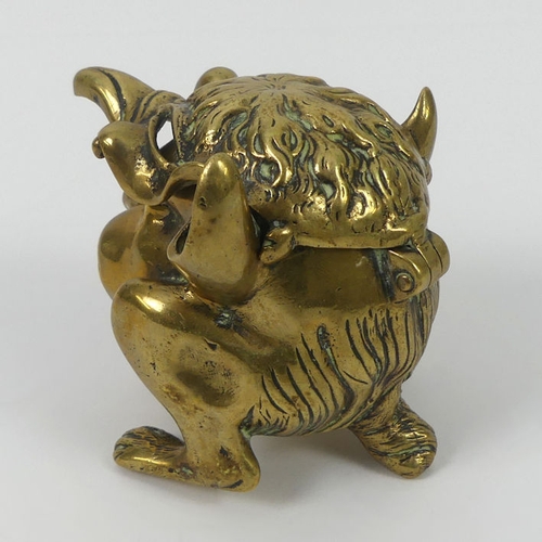 307 - A Victorian grotesque brass inkwell and penholder. 8 cm high.