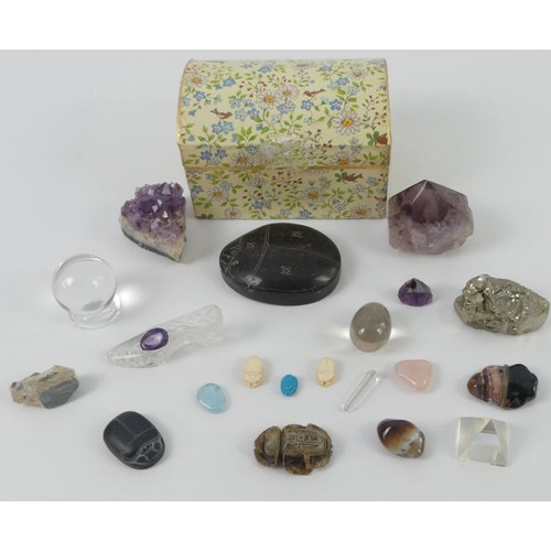 313 - A box of various uncut gemstones and carved scarab items.